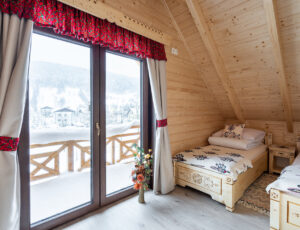 Widok na dwa góralskie łóżka pojedyncze, wyjście na balkon z pięknym widokiem na Skrzyczne