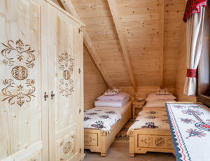 Sypialnia w stylu góralskim z widokiem na ogród.