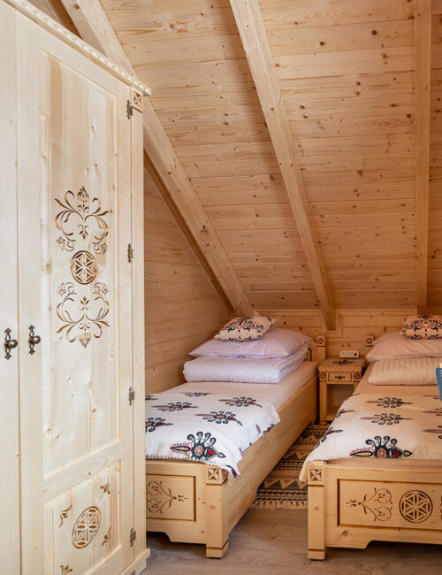 Sypialnia w stylu góralskim z widokiem na ogród.