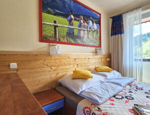 Przytulna sypialnia z dużym łóżkiem małżeńskim, delikatnymi kolorami i uroczym wystrojem.