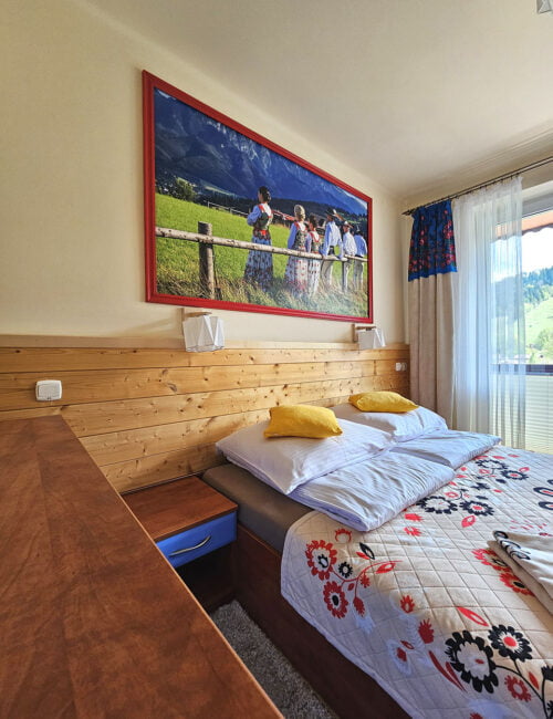 Przytulna sypialnia z dużym łóżkiem małżeńskim, delikatnymi kolorami i uroczym wystrojem.