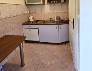 Aneks kuchenny w fioletowych barwach z płytą grzewczą, czajnikiem, lodówką i zlewem