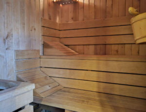 Wnętrze sauny w Willi Rosa z dwoma dużymi ławkami, wykonane całkowicie z drewna olchowego, zapewniające relaksujące noclegi.