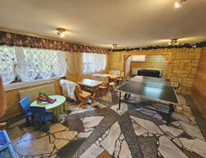 Świetlica z ping pongiem, góralskimi ławami, piłkarzykami, TV i kącikiem dla dzieci.