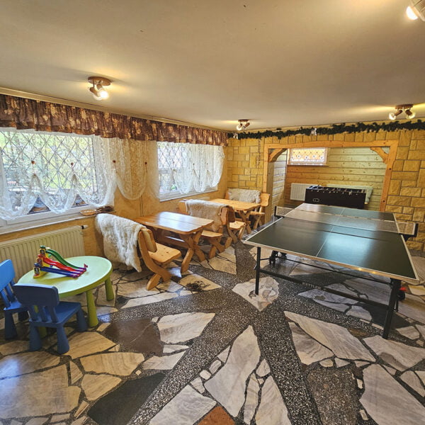 Świetlica z ping pongiem, góralskimi ławami, piłkarzykami, TV i kącikiem dla dzieci.