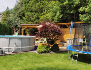 Basen i trampolina w ogrodzie Willi Rosa, z zadaszoną altanką i ozdobną drewnianą ścianką, idealne miejsce na noclegi w Szczyrku.