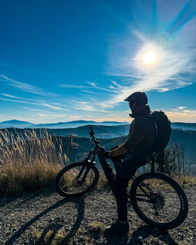 Rowerzysta na elektrycznym rowerze na tle gór